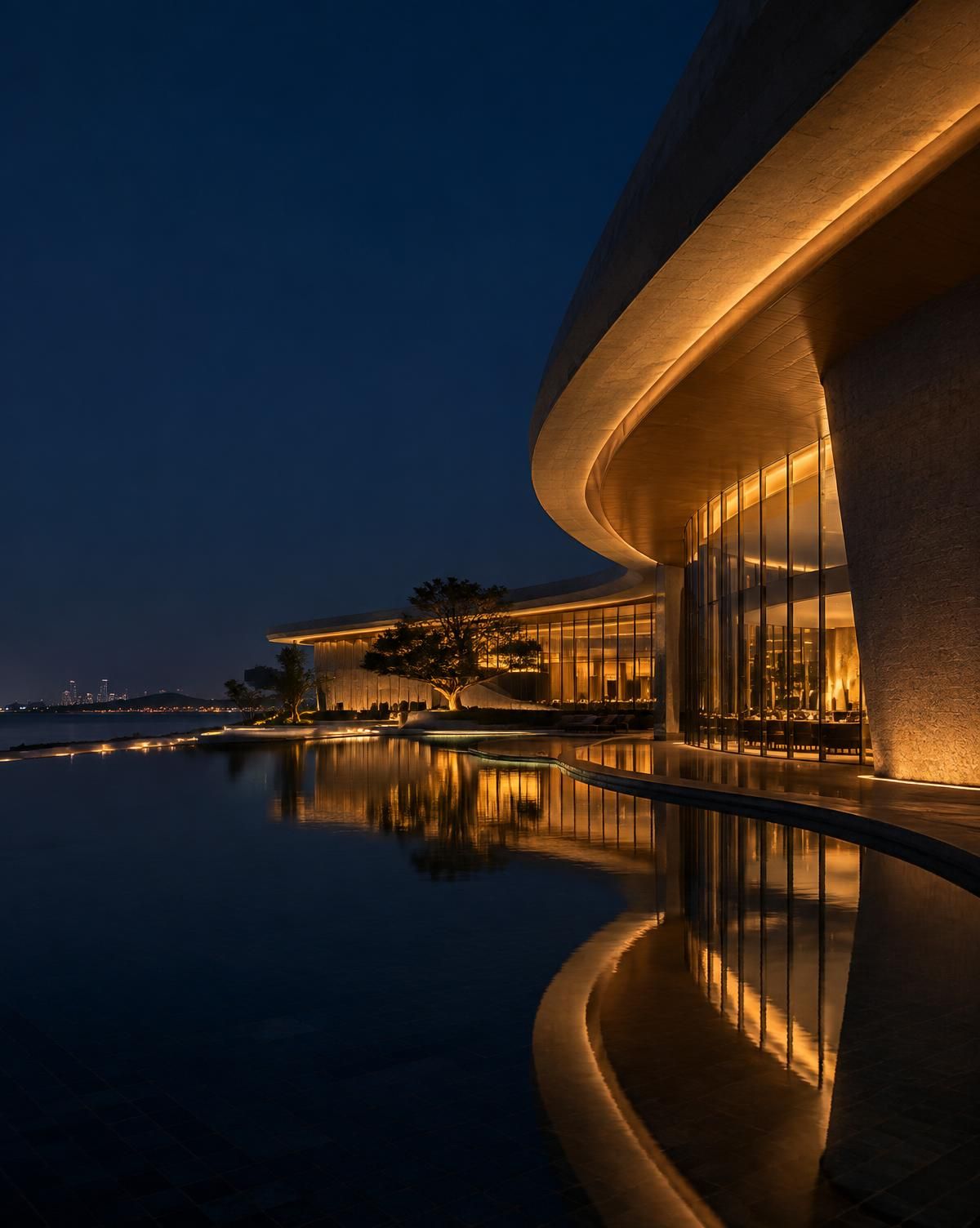 夜间暖光照亮的弧形度假村建筑，倒映在静水中